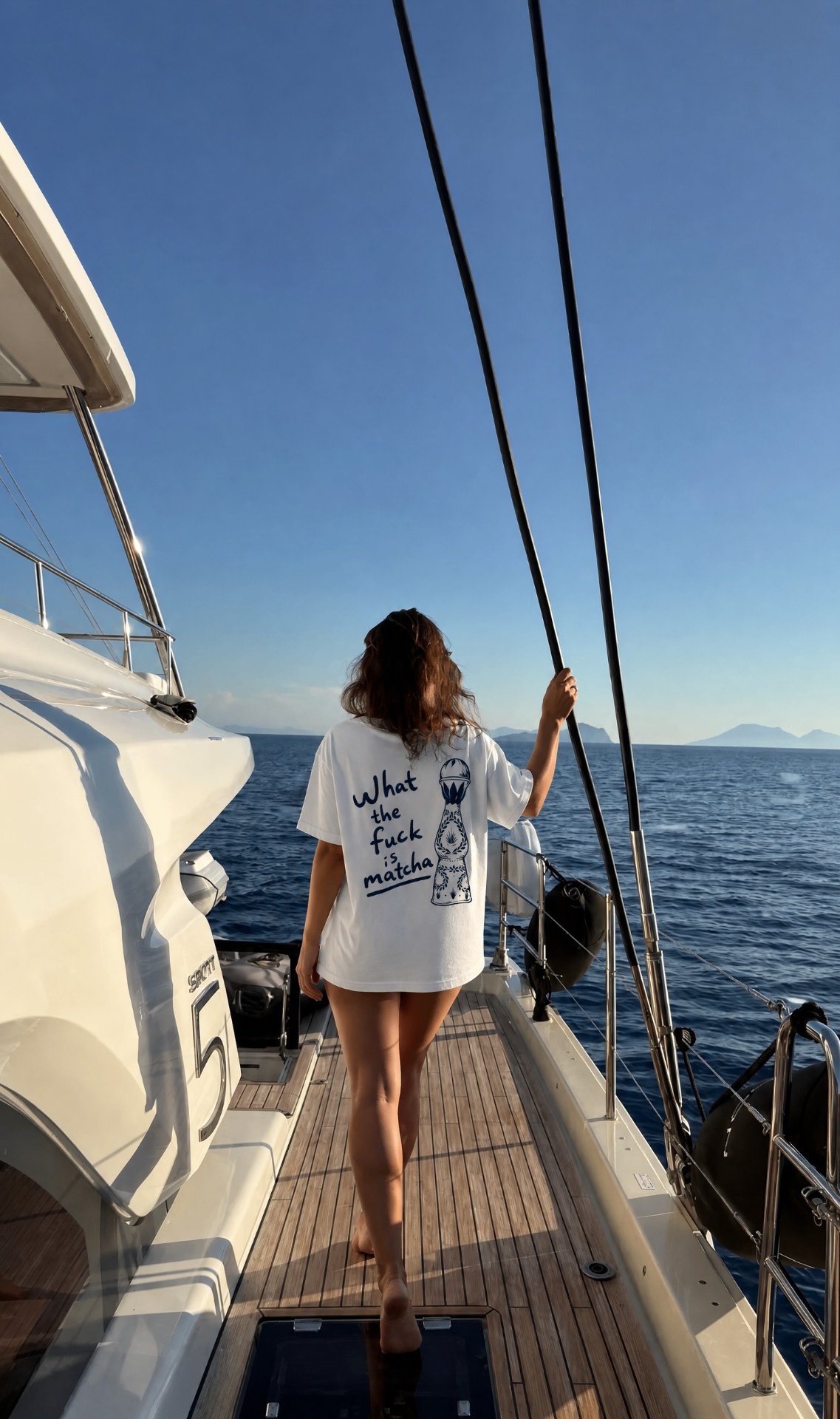 Matcha tee walking the deck of a sailboat