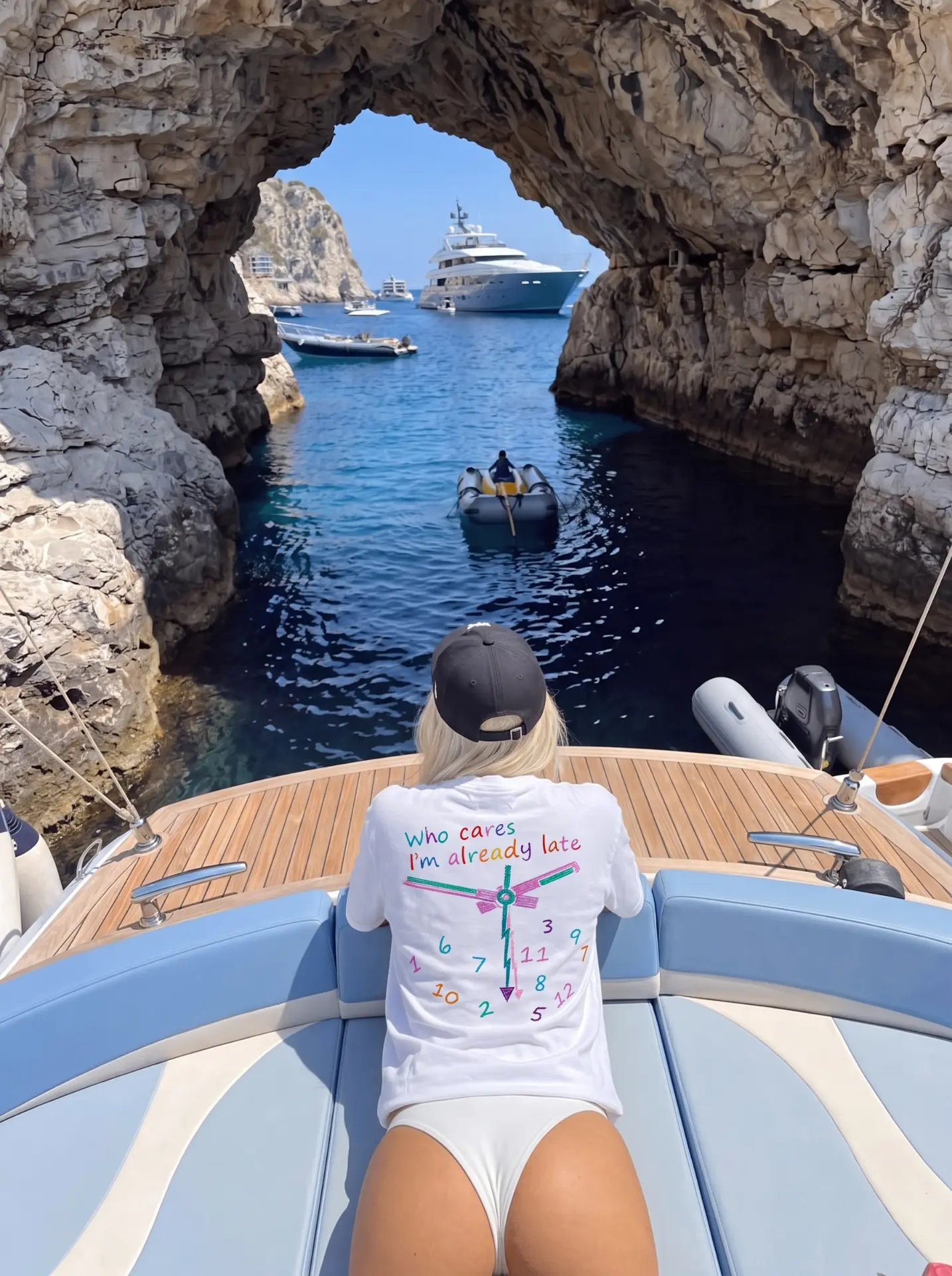 Who cares I'm already late tee on a boat bow inside a sea cave